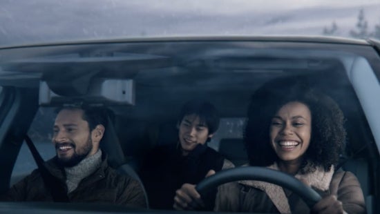Three passengers riding in a vehicle and smiling | Nissan of Pittsfield in Pittsfield MA