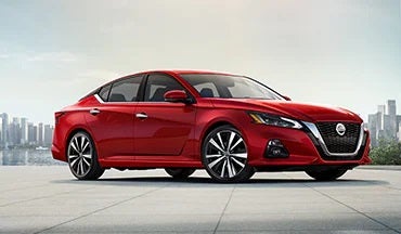 2023 Nissan Altima in red with city in background illustrating last year's 2022 model in Nissan of Pittsfield in Pittsfield MA